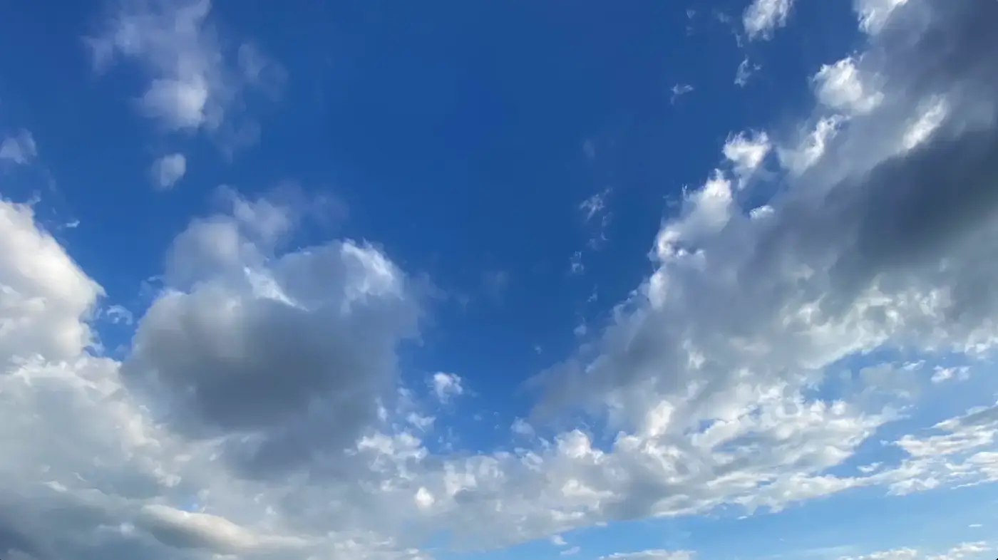 Blue sky with scattered, fluffy white and gray clouds, creating a peaceful and open atmosphere. AdvanceTrac